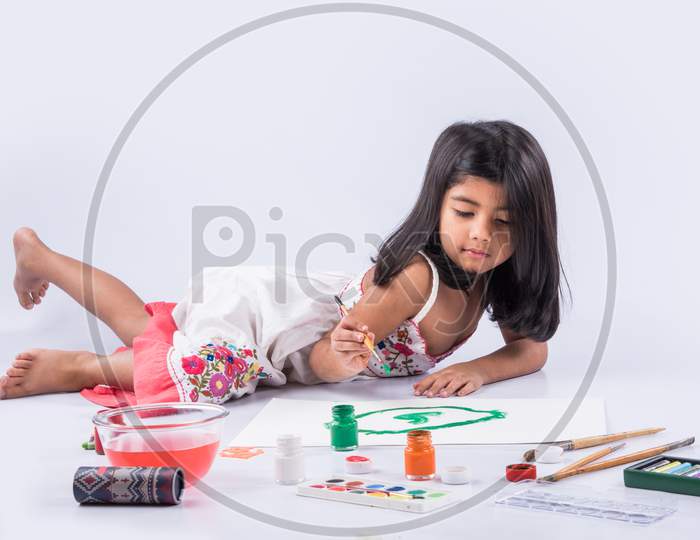 Little girl artist colouring with brush