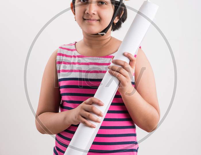 Indian small girl want to be an architect / engineer, wearing Yellow Hard Hat and holding paper drawing Roll