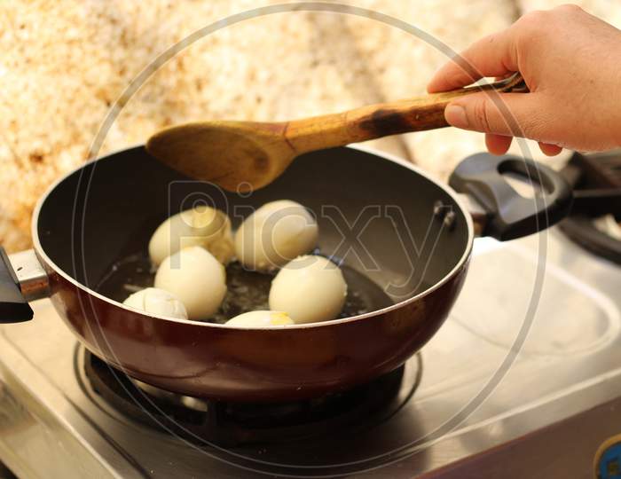 Frying boiled eggs on a back fry pan