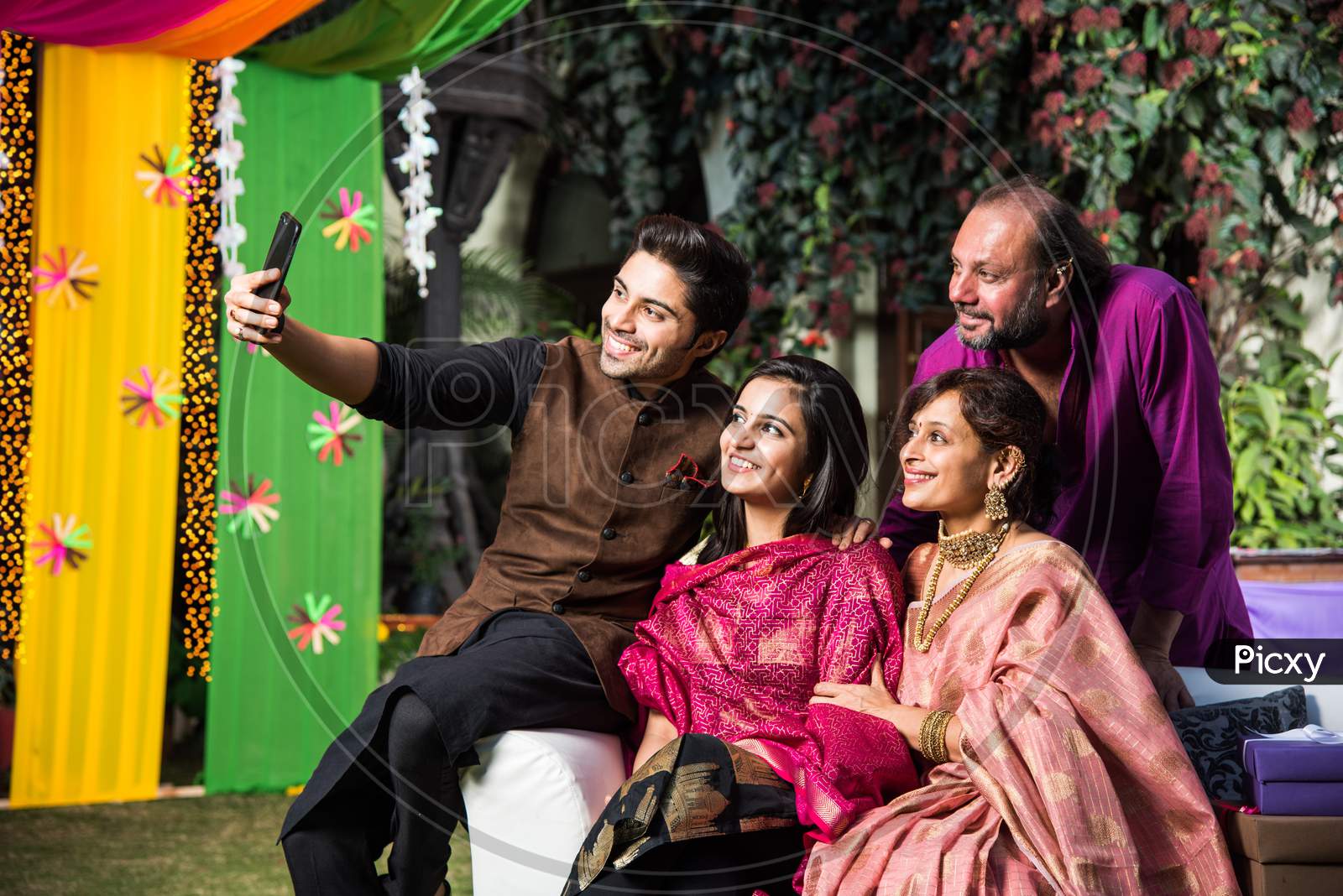 Indian family taking selfie picture using smartphone