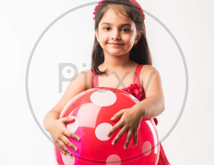 cute little indian/asian girl with colourful balloons or gubbare in Hindi, over white or red background