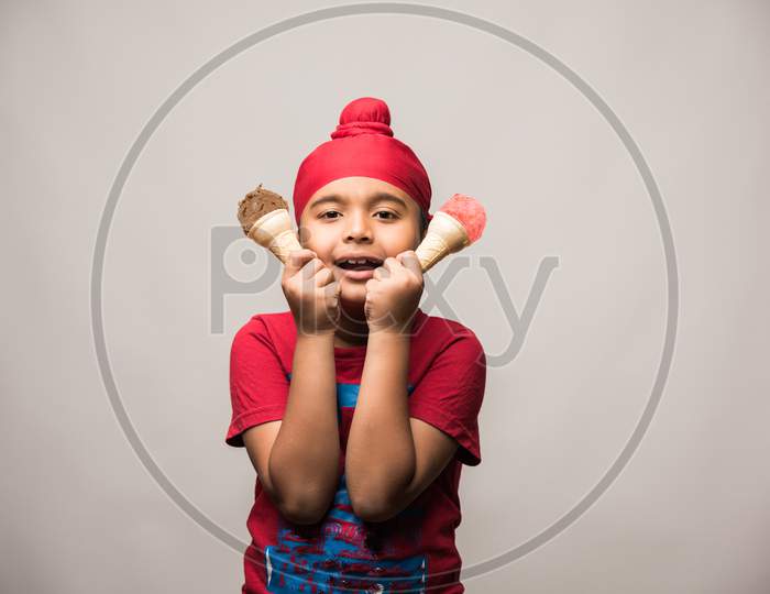 cute little Indian sikh/punjabi boy eating ice cream in cone