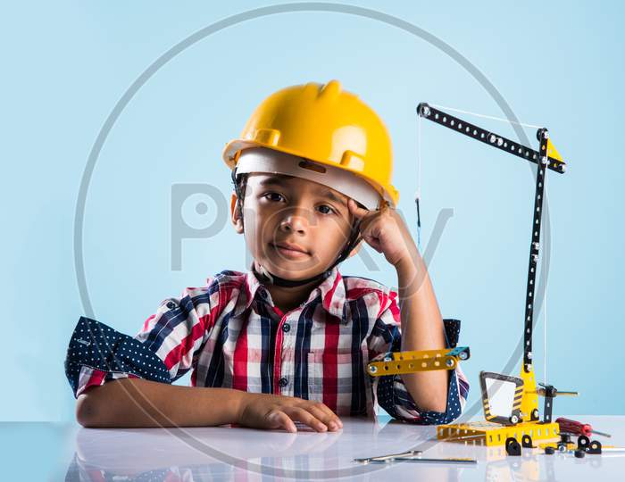 Cute little indian boy playing with toy crane