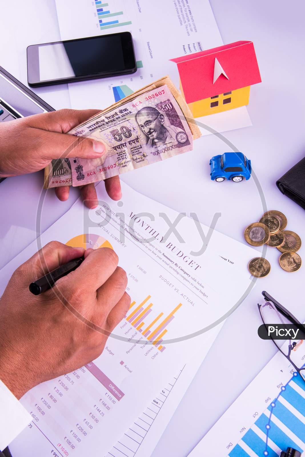 India and accounting concept showing accountant working on Income tax forms with currency notes, calculator and house/car 3d Mod