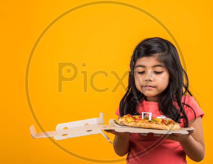 Cute little girl eating potato wafers or crispy chips
