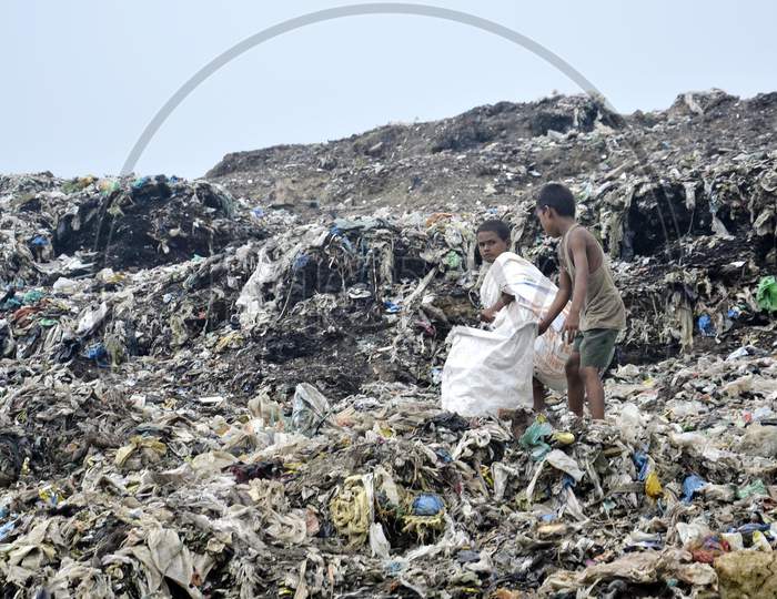 A rag picker  boy collecting plastic waste from a garbage dumping site