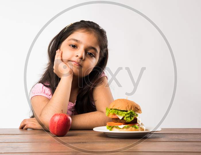 Llittle girl confused with Burger and apple