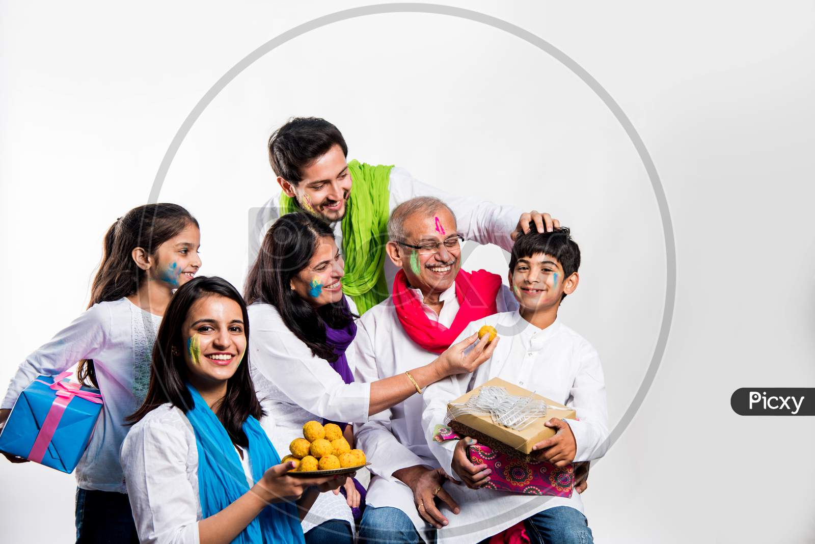 Family eating sweet laddu on Holi festival