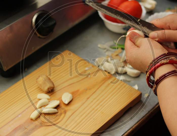 Woman Cutting Garlic by Knife.