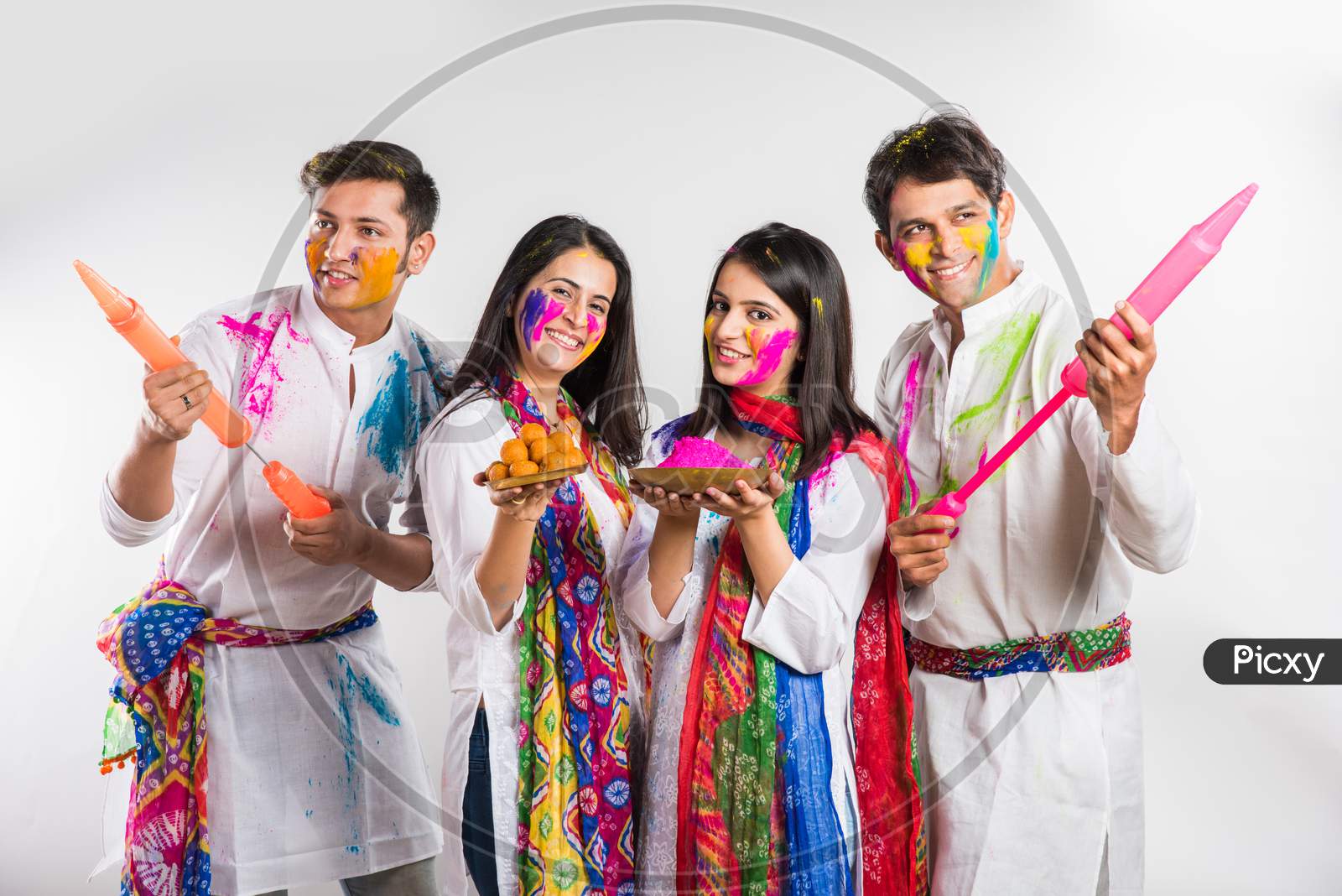 indian people celebrating Holi, festival of colours with plates full of colours and faces painted, happiness concept, standing i