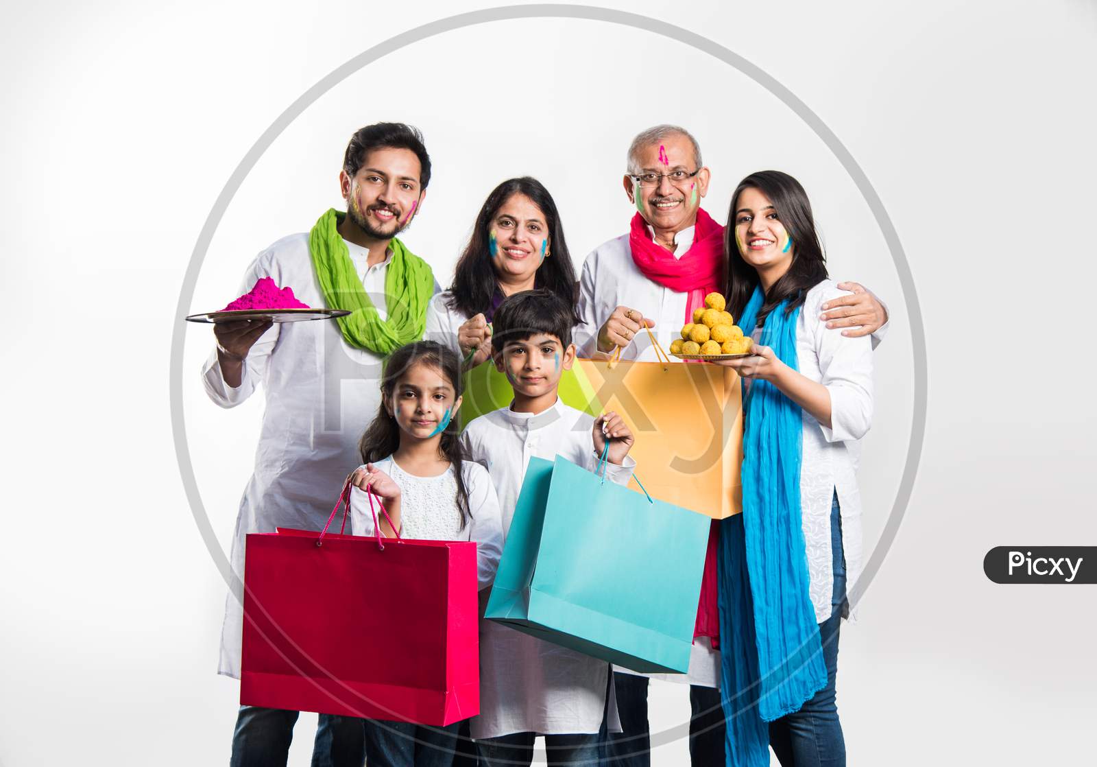 Indian Family playing holi posing for group photo over white background