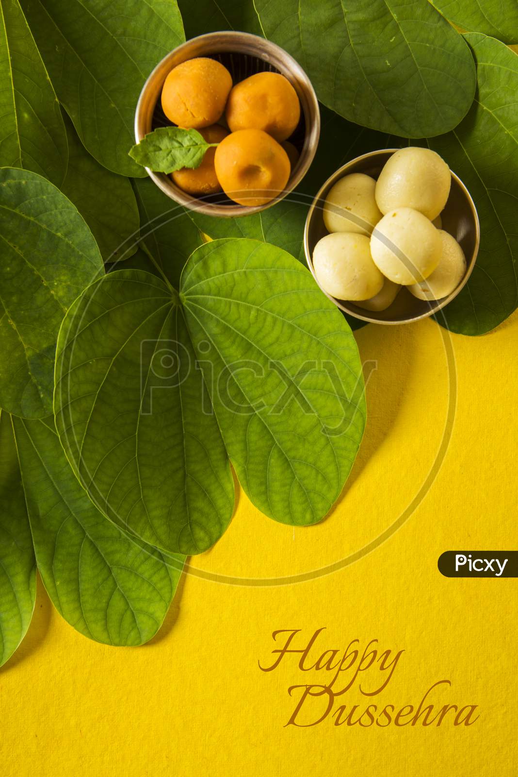 Happy Dussehra greeting card using apta  / Bauhinia racemosa / Bidi leaf with sweet pedha / peda / pera
