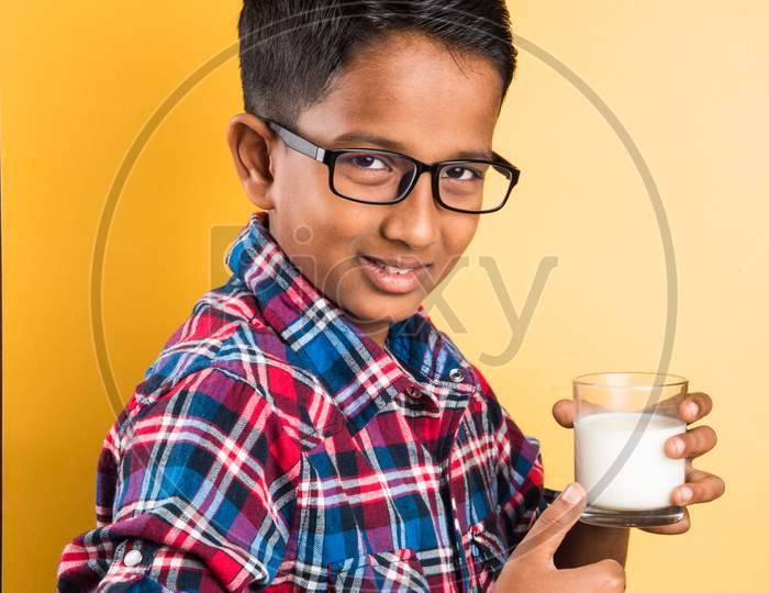 Small boy drinking plain milk in a glass