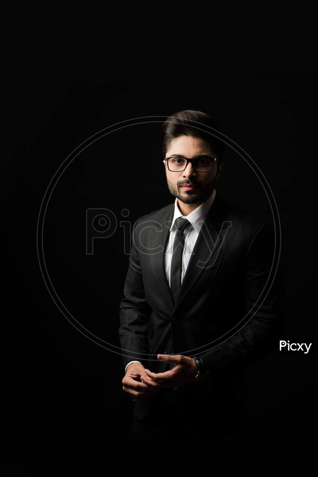 Image of Portrait of Indian Male businessman standing against black  background-HR374380-Picxy