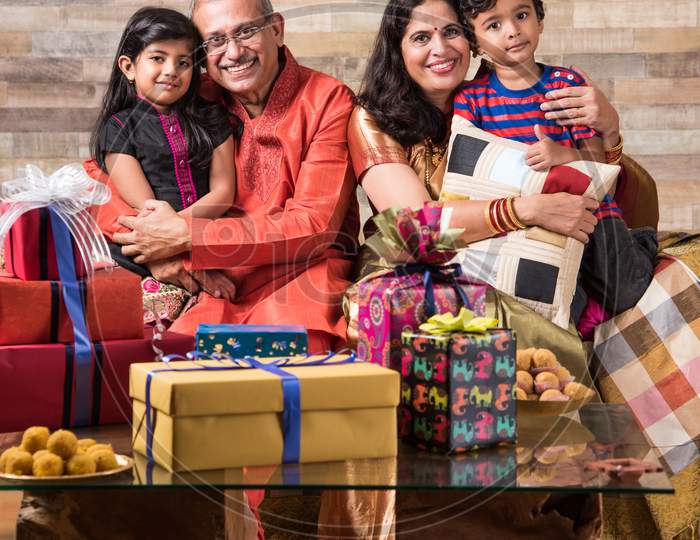 Indian family celebrating diwali with gifts and sweets