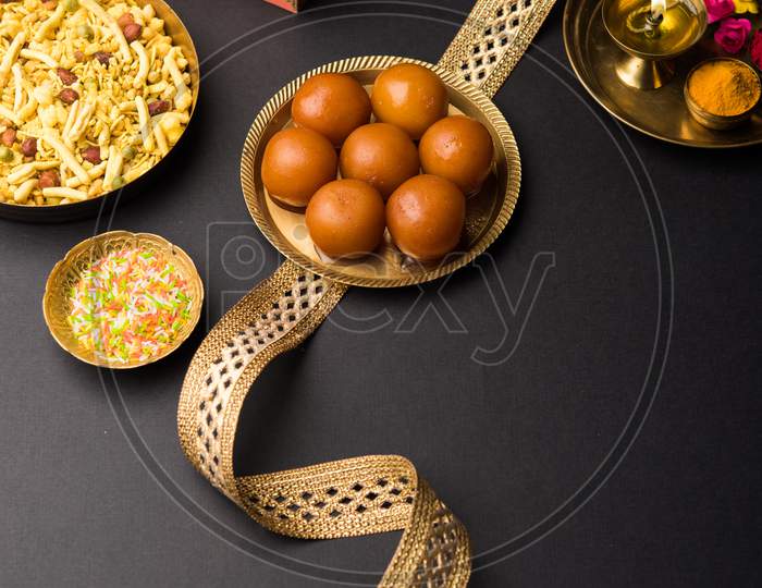 Raksha bandhan Festival : conceptual Rakhi made using plate full of sweets with band