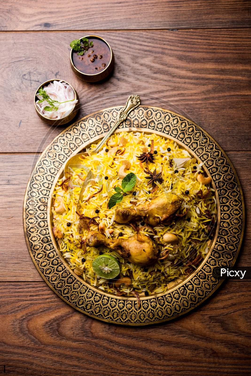 Chicken biryani in bowl over moody background