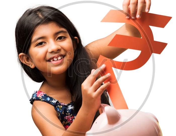 Small Girl inserting Paper Rupee symbol in piggybank