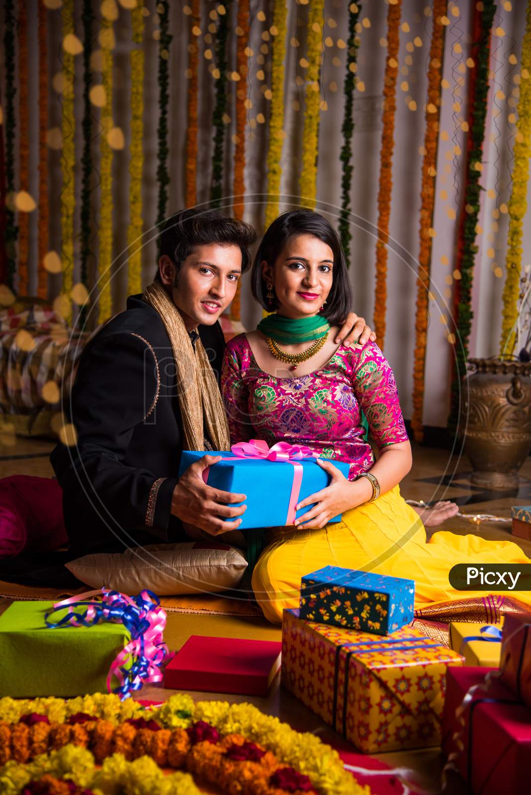 Indian young couple sitting close on diwali / anniversary