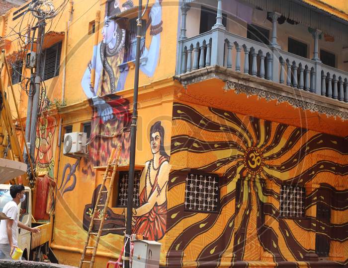 A man walks in front of a mural painting done on a house during the lockdown in Prayagraj, Uttar Pradesh on July 11, 2020