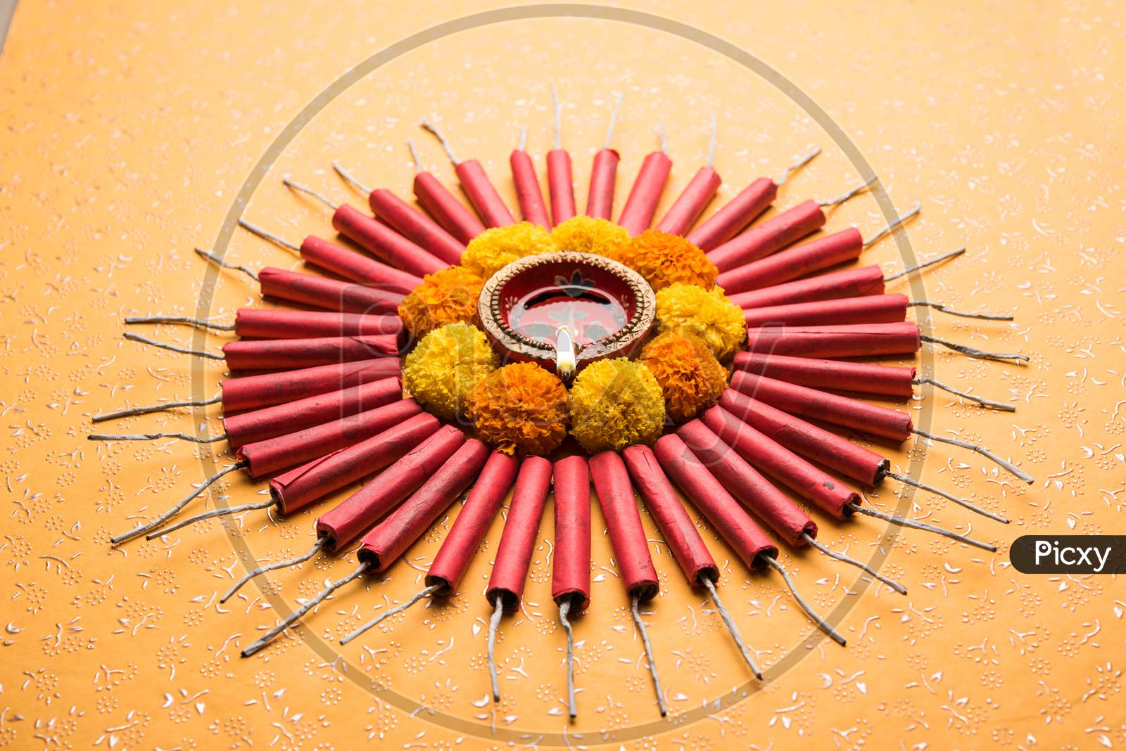 diwali rangoli using snacks, firecrackers and oil lamp or diya