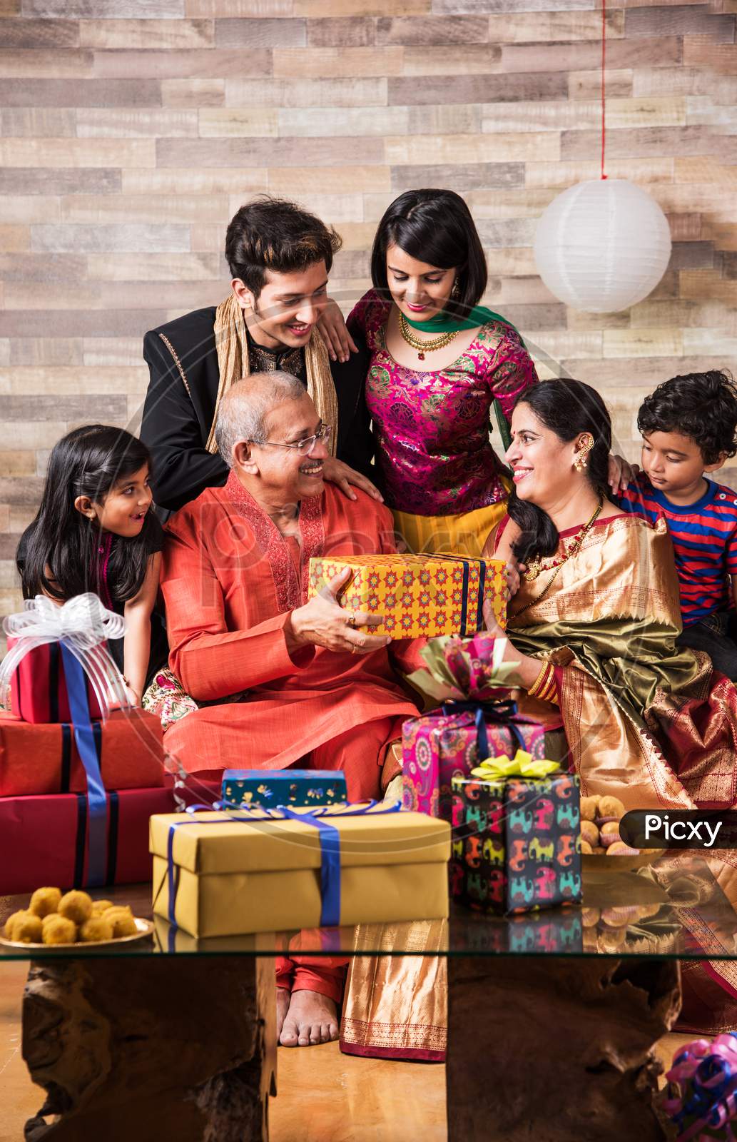 Indian family celebrating diwali with gifts and sweets