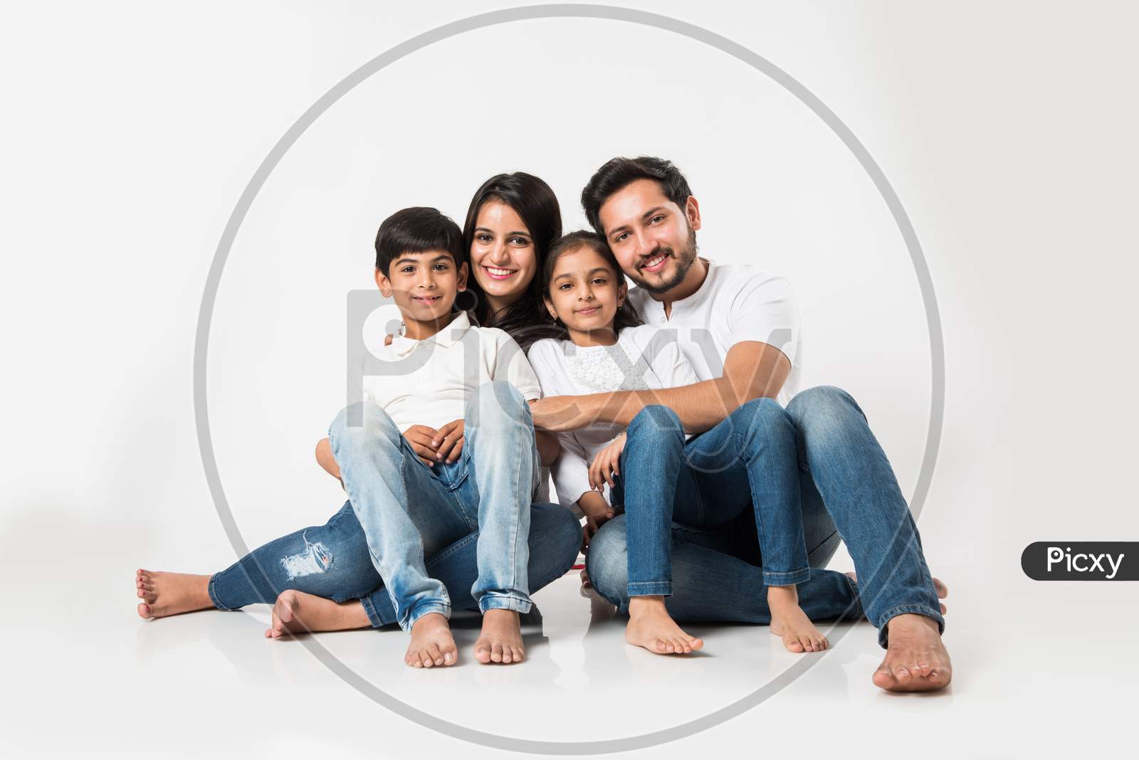 Young family sitting isolated over white