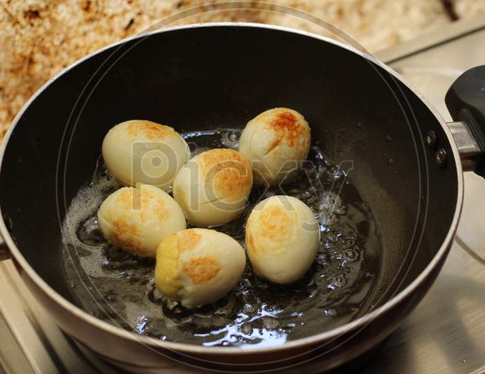 Frying boiled eggs on a back fry pan