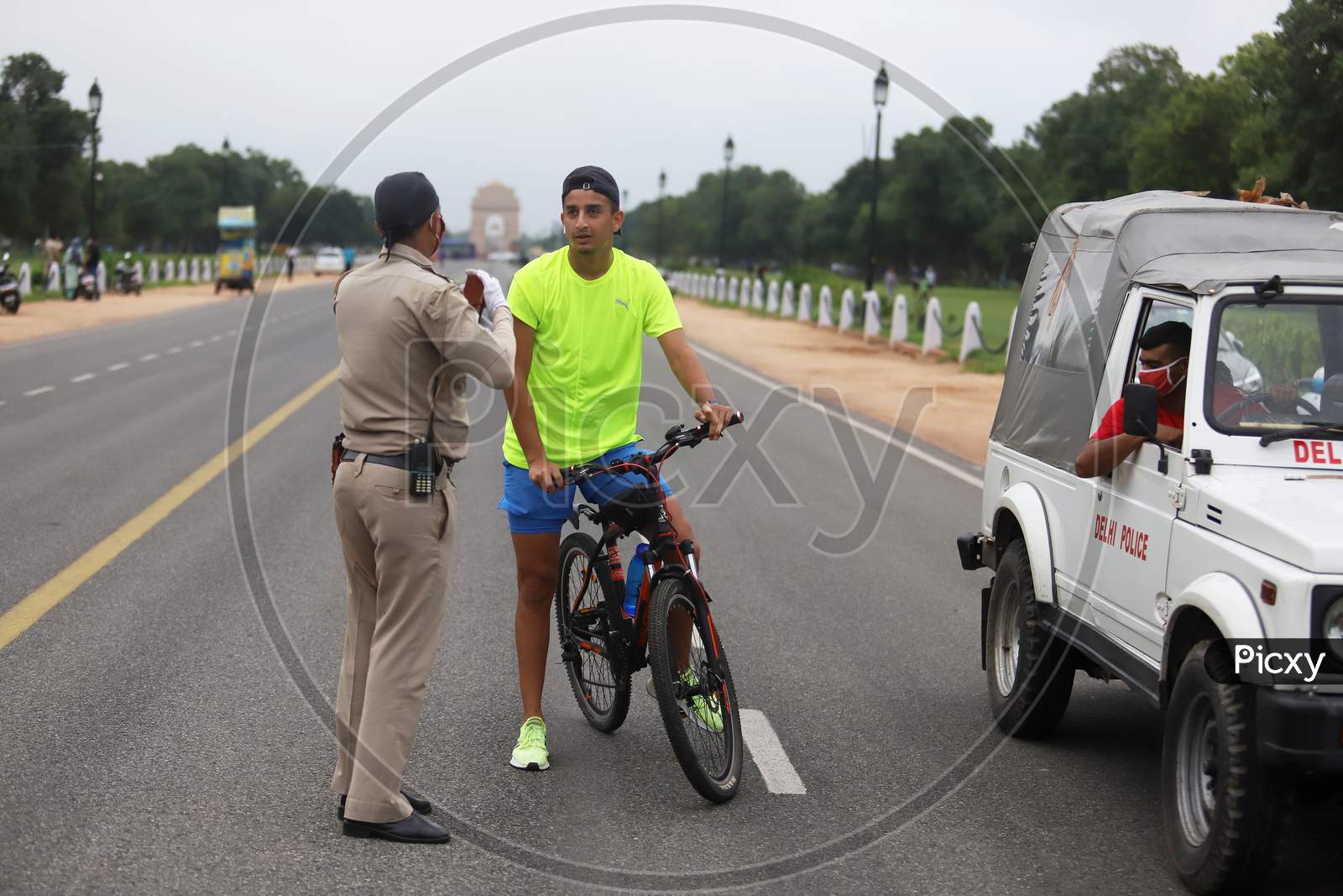 Delhi Police Official questions a cyclist for not wearing a mask near India Gate in New Delhi, India on July 07, 2020