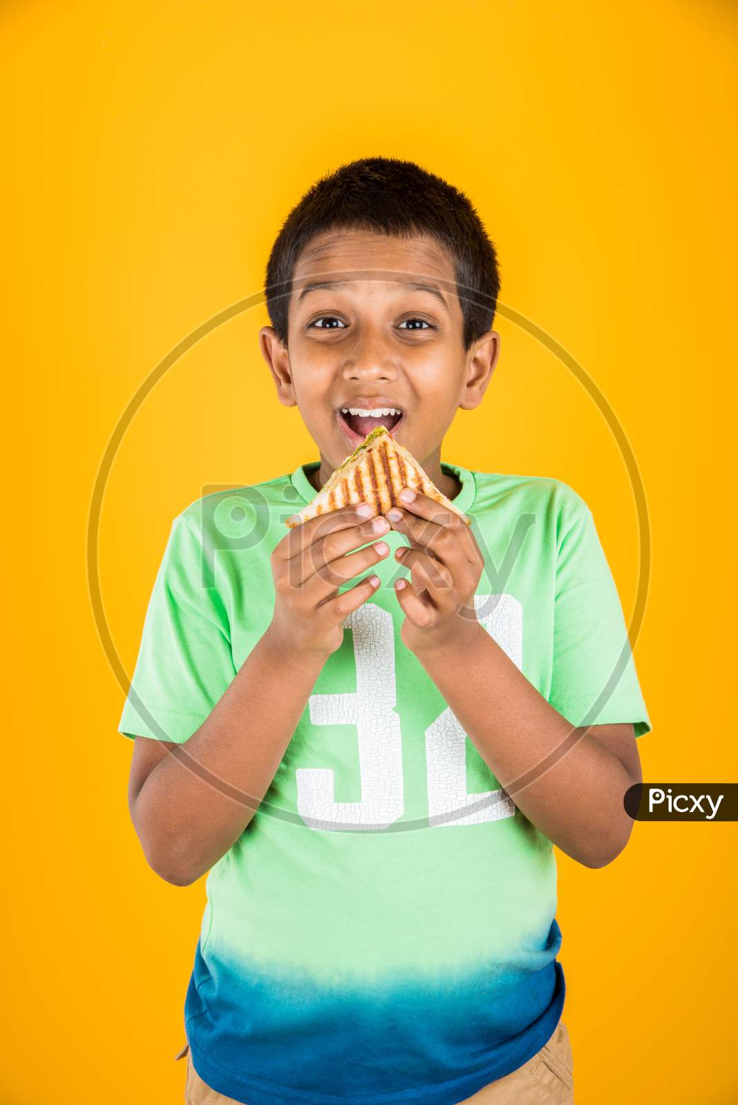 small boy child eating sandwich