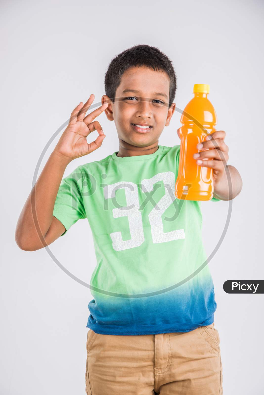 Cute little boy drinking mango juice or cold drink / beverage