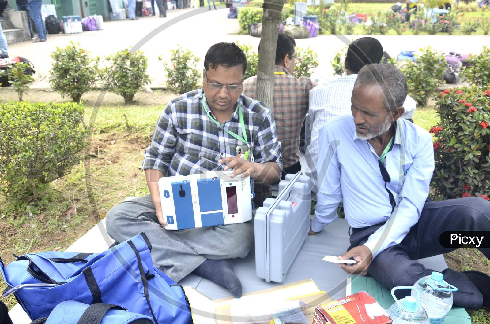 Polling officials check their EVMs and other election material