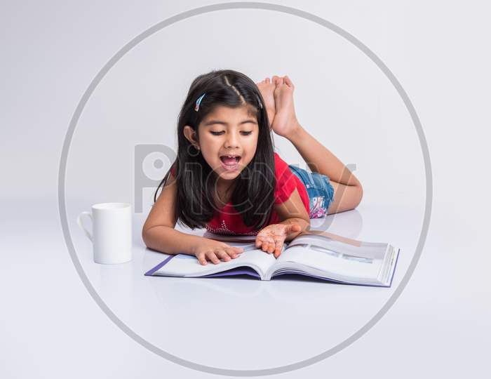 Indian school girl studying or reading book