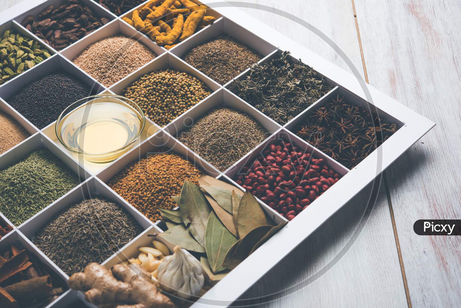 Indian Spices in white wooden box with cells, selective focus.