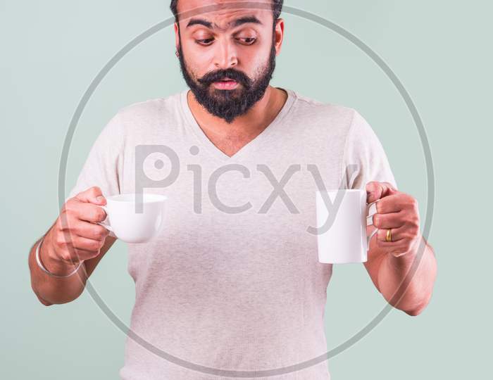 Indian Bearded young man drinking tea / coffee
