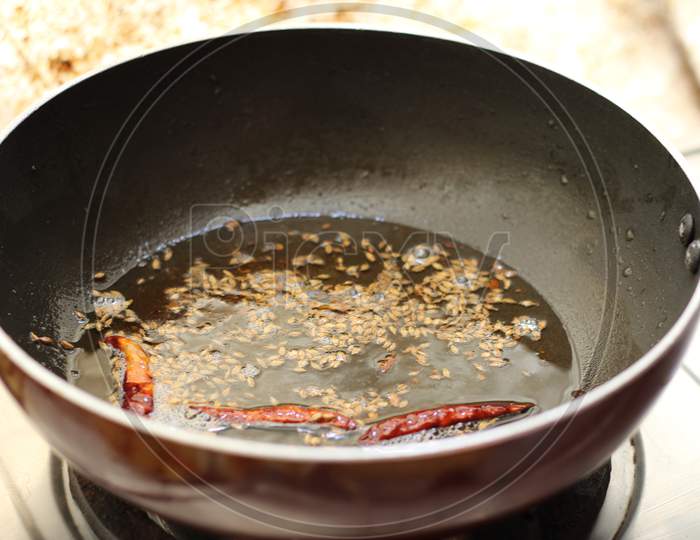 Zeera and red chili on black fry pan