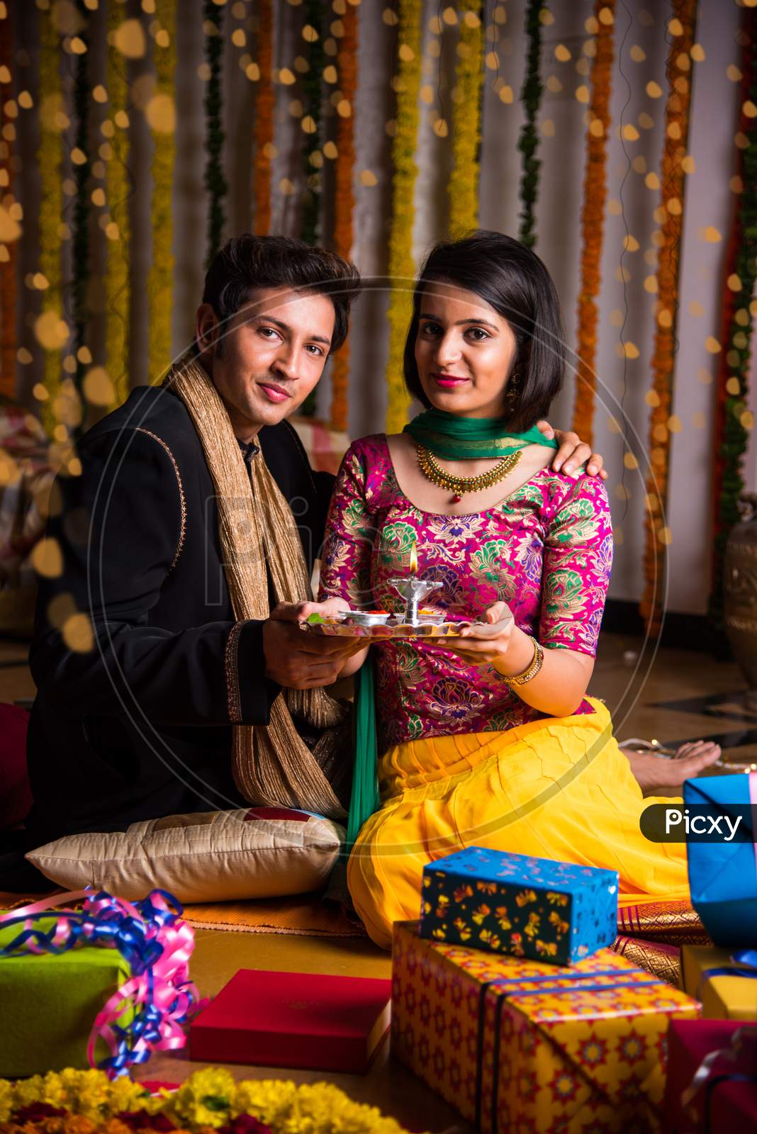 Indian young couple sitting close on diwali / anniversary