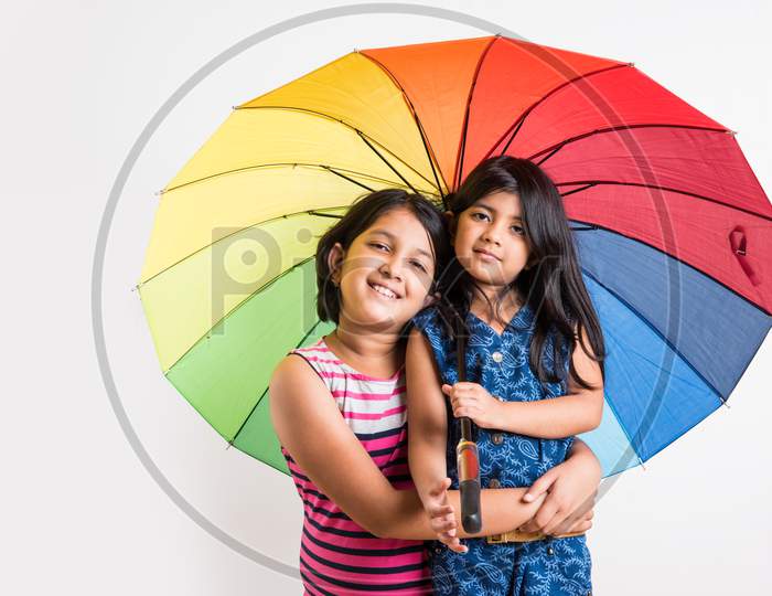 Indian Girl with big multicoloured umbrella, isolated over white