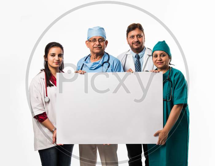 happy Indian/asian doctors holding blank white board