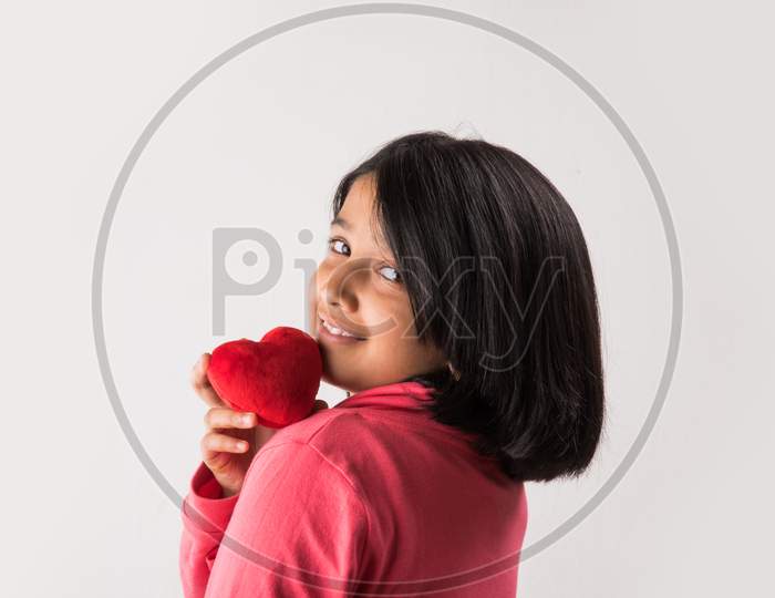 Small girl with stuffed heart toy
