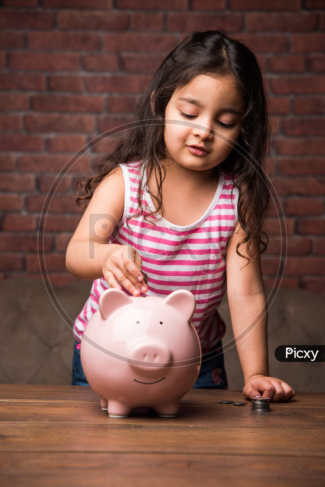 Indian small girl with piggy bank - saving concept