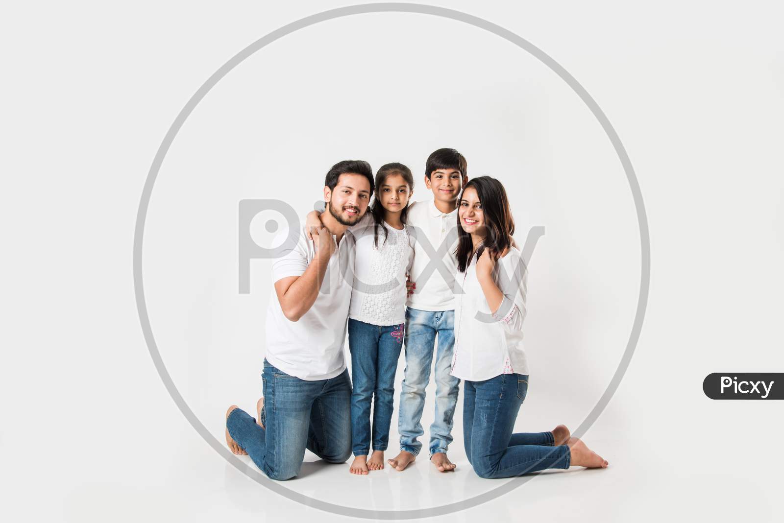 Young family of 4 standing over white