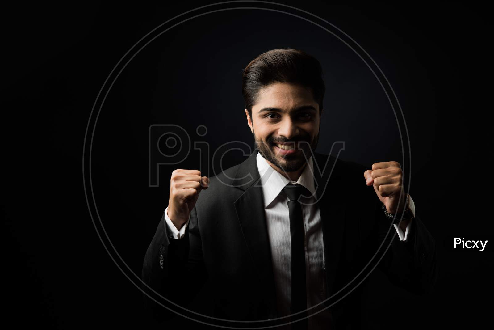 Indian Bearded Male businessman celebrating success with thumbs up or raising fist while standing isolated over white background