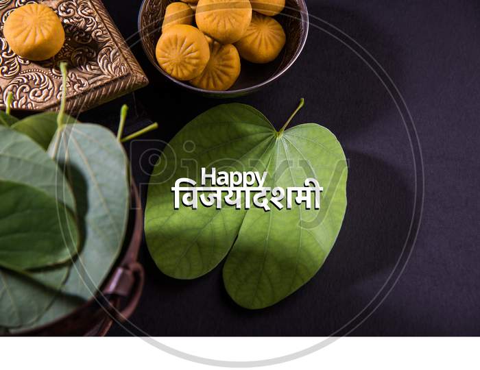 happy Dussehra / Ayudh Puja greeting card with Pedha /Pera and Apta Leaf