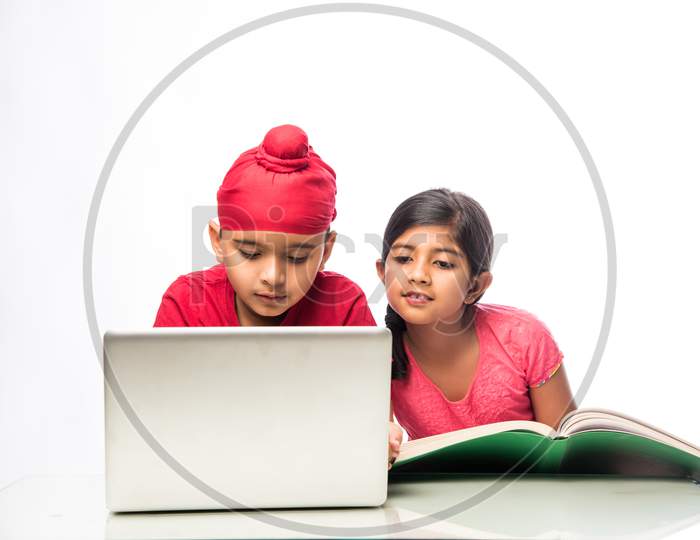 Indian Sikh/punjabi little boy studying with laptop and books at study table