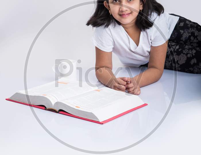 Indian school girl studying or reading book