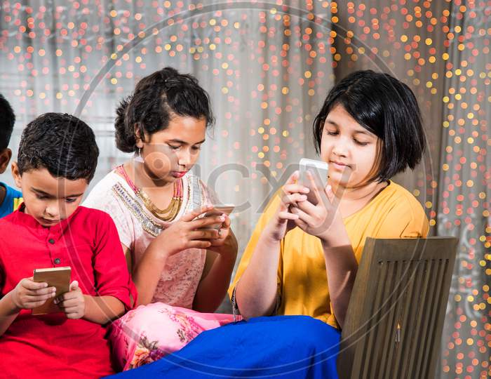 indian kids busy using smartphone in diwali - concept showing bad habbits