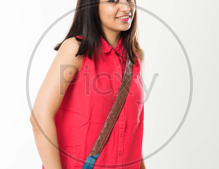 Pretty Indian/Asian College Girl holding books and bag while standing isolated over white background