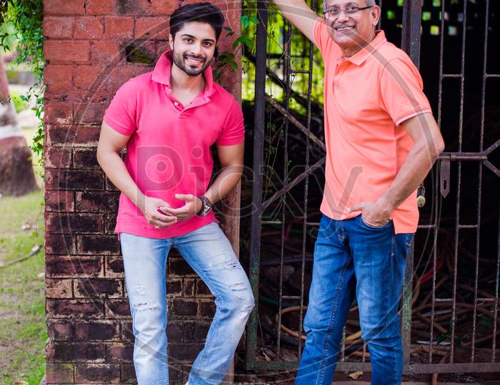 Young Man with Father posing against red brick wall, outdoor
