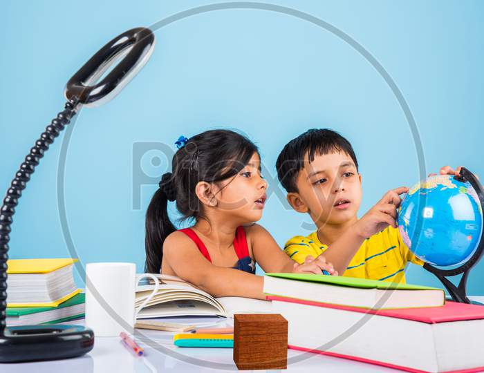 Indian school kids/siblings studying at home with books